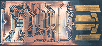 Close-up of a copper PCB with dense traces and a gold-plated edge connector on the right.